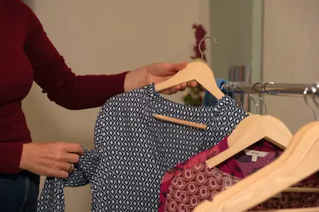 Kleidung an einer Kleiderstange wird für einen Kleiderschrank-Check gesichtet.